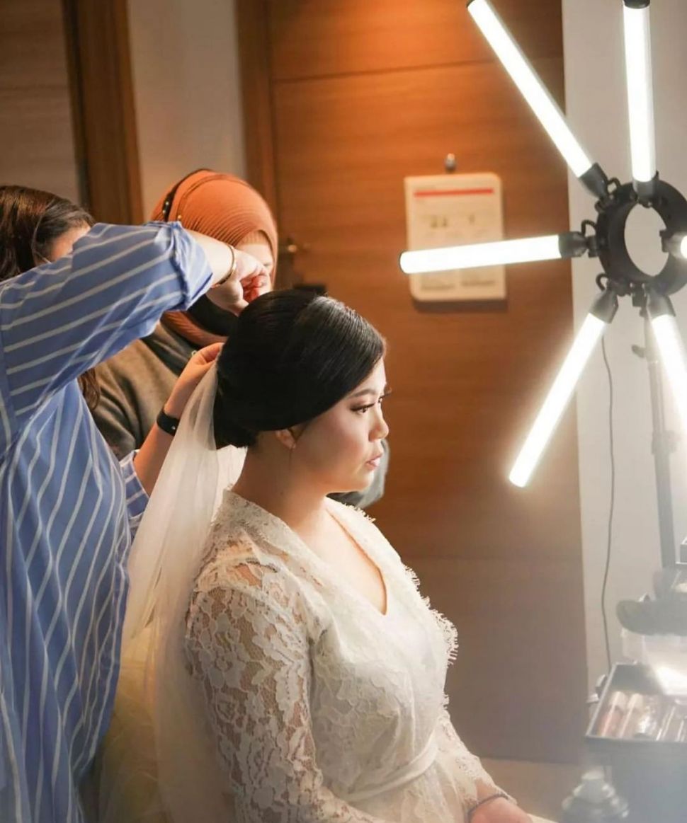 Tim dari Yunbridal tengah memasangkan gaun kepada seorang pengantin perempuan. [Instagram]