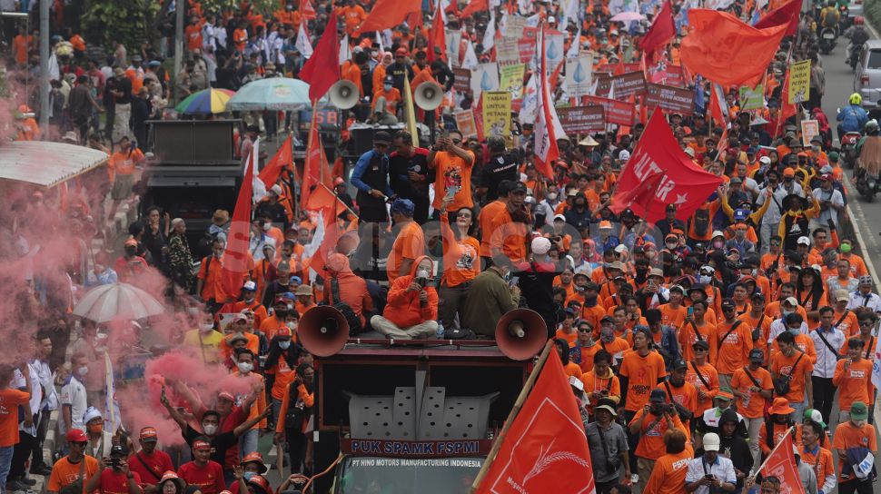 Sejumlah massa buruh melakukan 'long march' menuju Stadion Gelora Bung Karno usai berunjuk rasa di depan gedung DPR RI, Jakarta, Sabtu (14/5/2022). [Suara.com/Angga Budhiyanto]